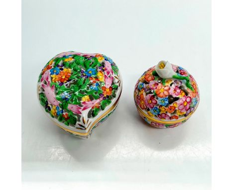 Heart and spherical-shaped porcelain boxes with open work lids. Both boxes feature tiny floral pattern designs and gold-gilde