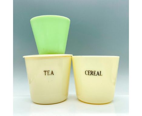 Three kitchen jars, one with lid, all made with uranium glass that glows under black or UV light. Two cream colored are marke