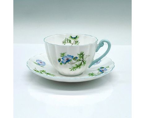 Tea cup and saucer set, depicting hand painted blue flowers. Light blue trim. Shelley backstamps. Cup: 4.25"L x 3.5"W x 2.25"