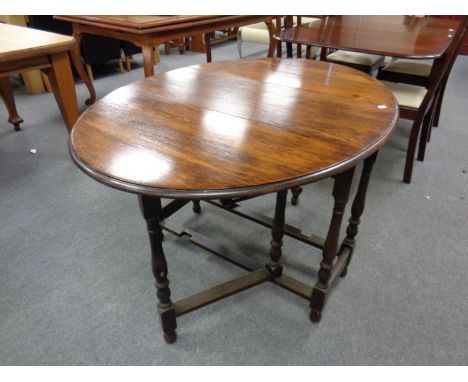 An Edwardian oak gate leg table and a small footstool 