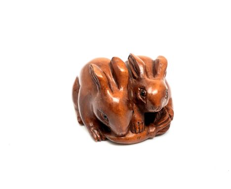 A carved Chinese hardwood netsuke - Two rabbits 