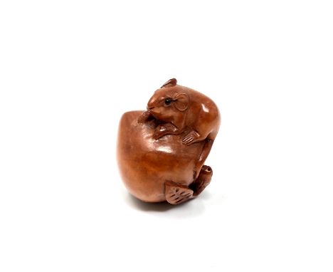 A carved Chinese hardwood netsuke - Rat standing on a peach