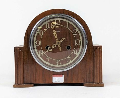 An Art Deco Enfield walnut cased dome top mantel clock, the applied metal chapter ring with Arabic markers and twin winding h