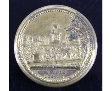 A late Victorian gilt metal container of circular form, the cover relief decorated with a view of Windsor Castle, the base wi