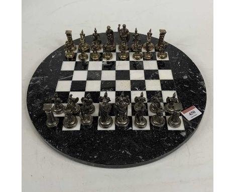 A polished hardstone chess board, together with two chess sets