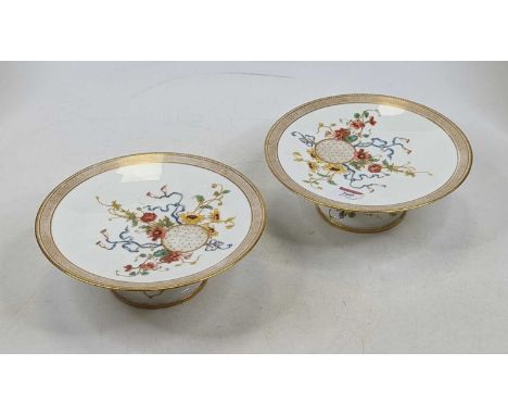 A pair of Victorian porcelain pedestal cake stands, each hand painted with flowers within a gilt rim, dia. 23cm
