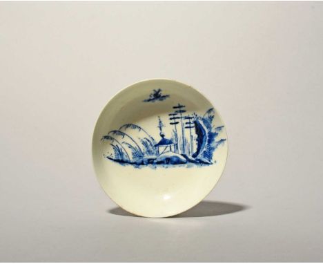 A Longton Hall or West Pans blue and white saucer, c.1760-65, painted with a Chinese landscape depicting a small hut beneath 