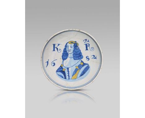 A rare delftware Royal dish, dated 1682, painted in blue and yellow with a portrait of Catherine of Braganza inscribed '2 / K