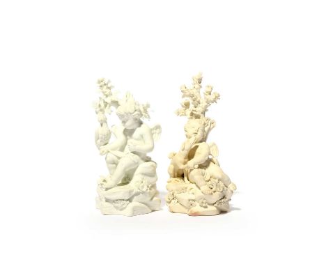 Two Derby biscuit porcelain figures of putti hunting, c.1780, each seated on a rocky stump beneath a tree, one with a blinker