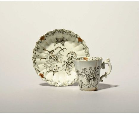 A rare Worcester coffee cup and saucer, c.1753-54, the cup of quatrefoil form with an elaborate scroll handle, the saucer wit