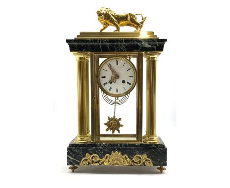 Late 19th century Empire design four glass, brass and marble mantel clock, surmounted by brass lion, over four reeded columns