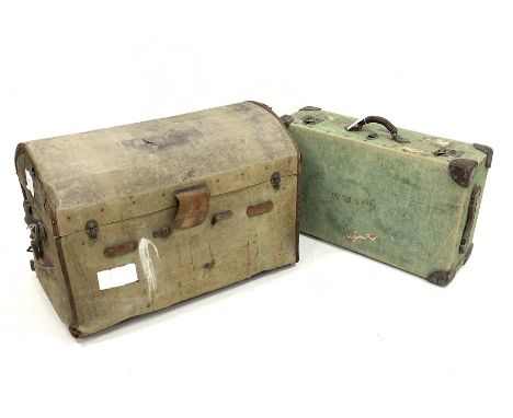Early 20th century canvas covered dome top travelling trunk, with handle to each end and with old paper labels, interior bari