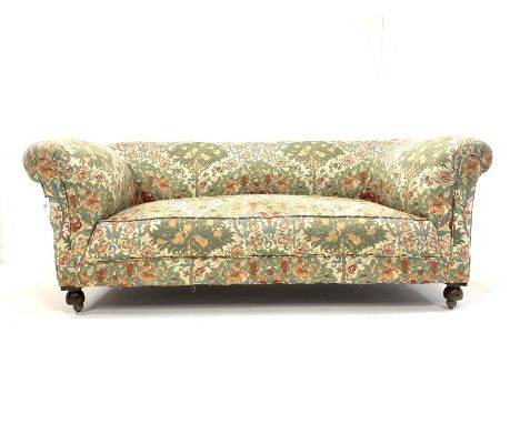 20th century drop arm chesterfield two seat sofa, upholstered in floral linen, and raised on  front bun supports and castors,