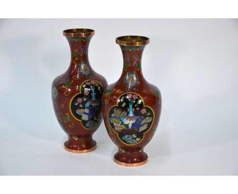 A pair of Chinese cloisonne baluster vases decorated in polychrome enamels with precious objects within quatrefoil panels res