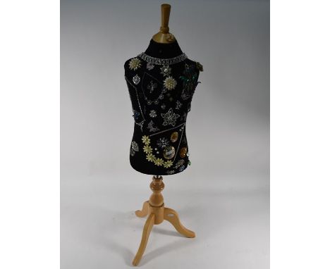 A modern child's tailor's dummy with collection of vintage and later costume jewellery attached a/f