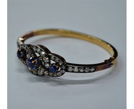 A diamond and blue sapphire bangle, the half-hinged yellow and rose gold bangle with silver set shoulders set with five gradu