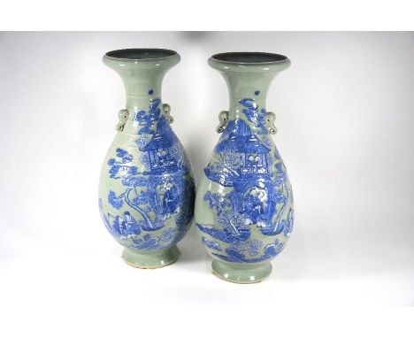 A large pair of Chinese blue and white celadon ground vases each with a ribbed pear-shaped body applied with two elephant mas