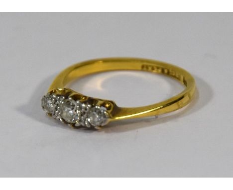 A three stone diamond claw set ring, 18ct yellow gold, stamped 18ct and PLAT, size K,