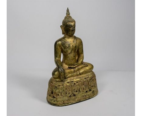 A 19th century Burmese gilt bronze figure of buddha wearing loose robes, seated with hands in bhumisparsha mudra on a reticul