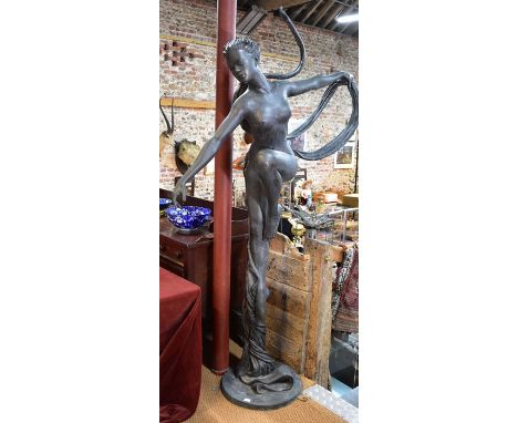 A large bronze patinated sculpture of an unclad female figure, on circular base, 232 cm h o/all (please note - this sculpture