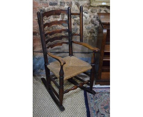 An 18th century oak ladder back rocking armchair,&nbsp; with rope seat