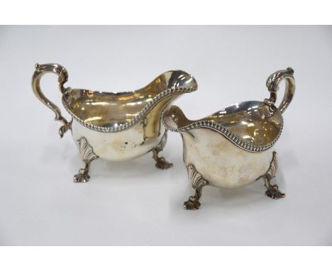 A pair of heavy quality William IV silver pot-bellied sauce-boats with gadrooned rims and scroll handles, on shell feet, R.S.