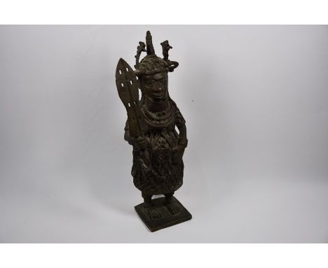 A Benin-style bronze figure of a heavily-armoured warrior with broad sword, 38 cm high