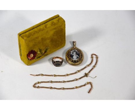 A Victorian style oval mourning locket with foliate chased case and black and white enamel decoration featuring ivy clad colu