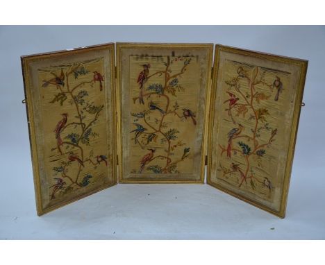 An antique giltwood framed triptych silk embroidered three panel folding screen, with colourful birds (the verso plain), 165 