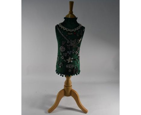 A modern child's tailors dummy with collection of vintage and later costume jewellery attached including necklaces, brooches,