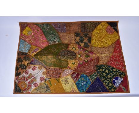 A vintage Indian patchwork wall hanging, profusely decorated with beading and embroidery