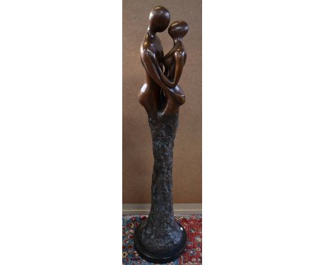 A brown bronze figural sculpture of a kissing couple, on circular marble plinth, 124 cm h o/all