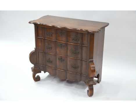 An antique continental oak three drawer commode chest, with lobed corner top, raised on scroll front legs, 85 cm x 41.5 cm x 