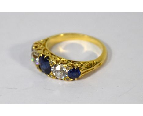 A sapphire and diamond ring, the three blue sapphires with old cut diamonds and diamond points between, in scroll setting wit