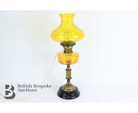 Amber coloured oil lamp, converted to electricity, with an amber coloured reservoir and shade and a clear funnel, approx&nbsp