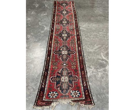 A red ground eastern carpet runner. 151' x 33'