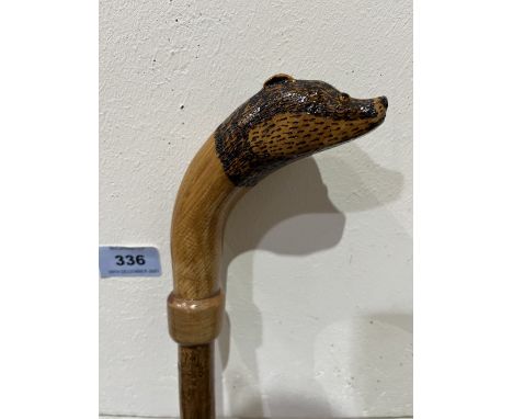 A hazel walking stick, the pommel a carved oak badger with glass eyes. 50½' long