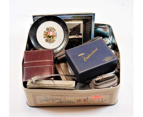 A box of miscellaneous items to include continental travel clock, table cigarette lighters, paper weight etc