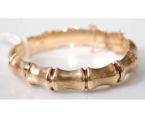A 9ct gold simulated bamboo hinged bangle, with safety chain, Circa 1970's with English hallmarks 15.5g, 6.5cm
