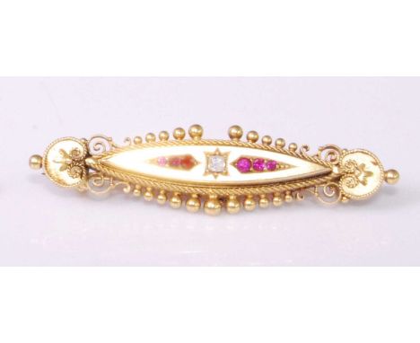 A late Victorian 15ct gold, ruby and diamond set elliptical brooch, having finely worked scroll ends and safety chain, 6.3g, 