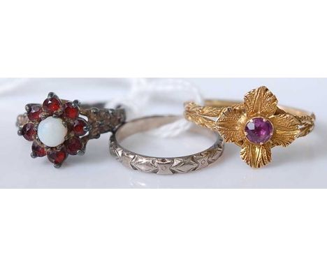 A yellow metal amethyst set flower head dress ring; together with a white metal, opal and garnet dress ring; and an 18ct gold