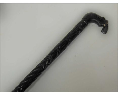 An early 20th century ebony walking stick, the handle carved as an elephant, length 94cm