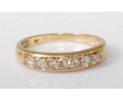 An 18ct gold diamond half hoop ring, the seven claw set brilliants in a line setting, total diamond weight estimated as appro