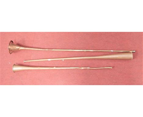 A copper hunting horn; together with two other similar (a/f)