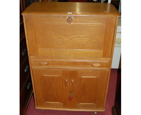 An Ercol blond elm side cabinet, having fallfront fitted compartment over single long drawer to twin lower cupboard doors, w.