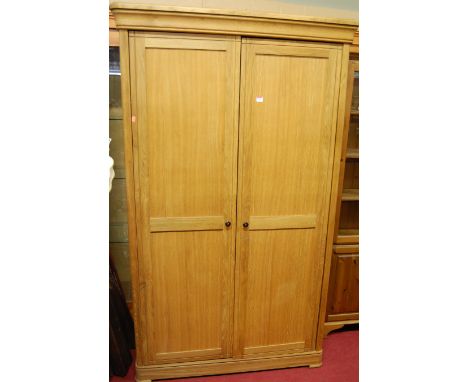 A contemporary light oak round cornered double door wardrobe, fitted with single shelf and interior rail, w.120cm 