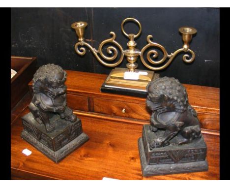 A pair of cast metal Dogs of Fo and a brass candlestick
