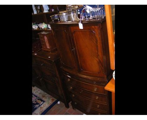 A mahogany bow front drinks cabinet with faux drawers below and pull out shelf