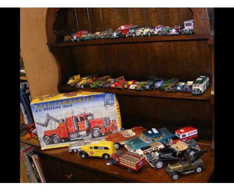 An assembly of die cast model vehicles - Corgi, Ertl and Matchbox, etc. - on three shelves 