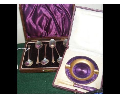 An enamel cigarette holder and ashtray, together with a set of six cased silver teaspoons 